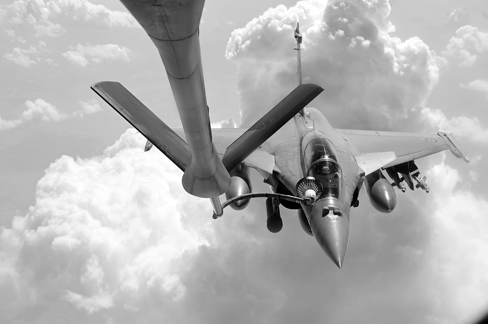 A US Air Force tanker refuels a French Air Force Rafale above the clouds