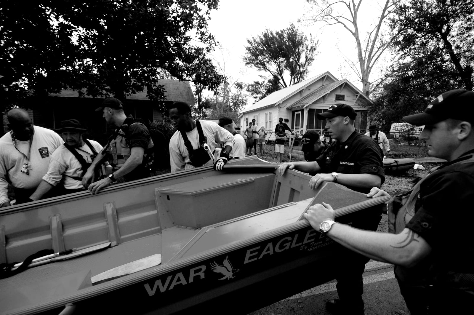 Rescue teams from several agencies carry a boat together during a flood response